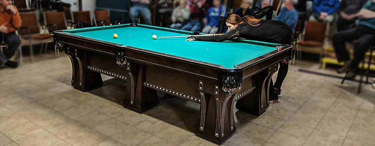 professional pool player playing on an antique used pool table at the Pro Billiards event.