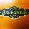 Authentic Brunswick logo on rail of Mission pool table.