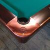 Flush metal pockets from overhead on a Brunswick Gold Crown IV pool table.