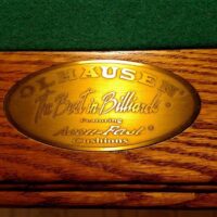 Olhausen metal stamped logo on rail of pool table