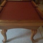 Overhead end view of a used Proline pool table with red cloth.