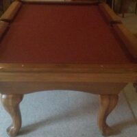 Overhead end view of a used Proline pool table with red cloth.