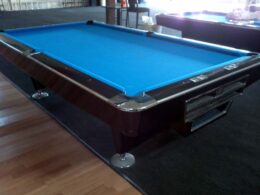 Brunswick Gold Grown III Pool table in piano black, blue cloth, and chrom accents.