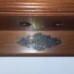 Brunswick logo on a traditional cherry cue rack.