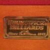 Brunswick Billiards metal logo embossed on the rail of this Dominion pool table.