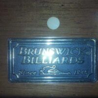 Brunswick Billiards logo plate on the Bridgeport pool table.