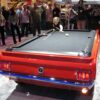 A difficult shot being made on a 1965 Ford Mustang pool table from Car Pool Tables.