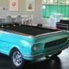 A 1965 Ford Mustang car pool table in powder blue on a hardwood floor in a modern game room.