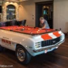 Mario Andretti taking a shot on his very own signature 1969 Chevy Camaro pool table from Car Pool Tables.