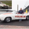 Mario Andretti standing next to his 1969 Chevy Camaro Official Pace car.
