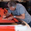 Mario Andretti signing the authenticity of a limited edition pool table paperwork.